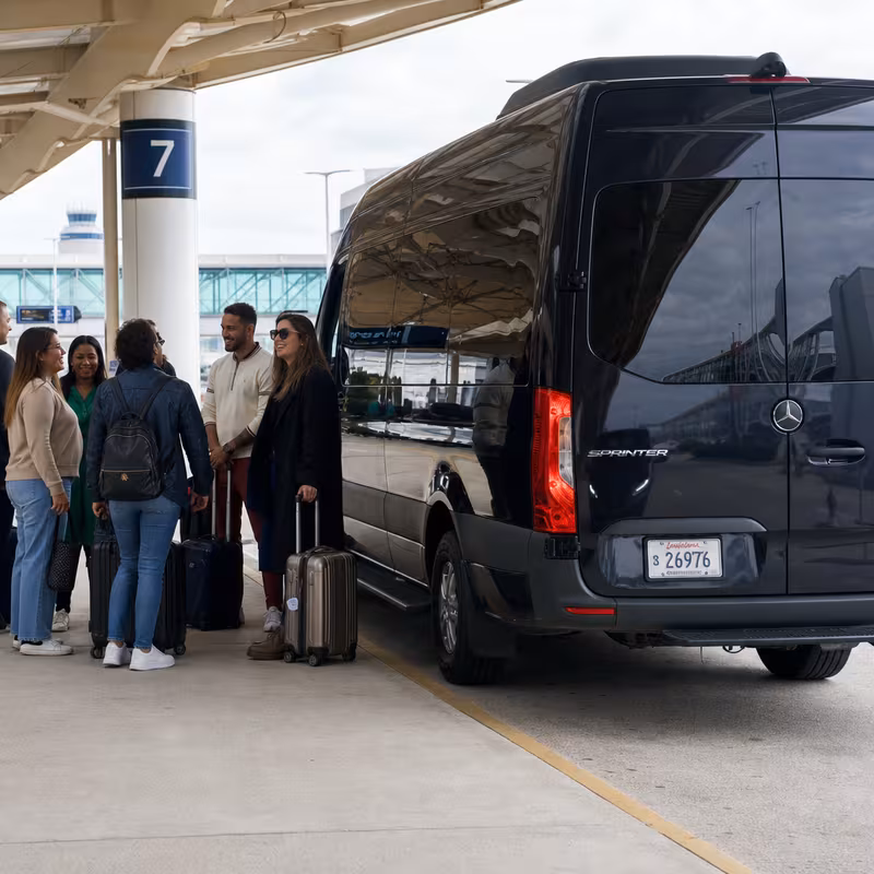 Group boarding a white charter bus for Airport Transportation transportation in New Orleans