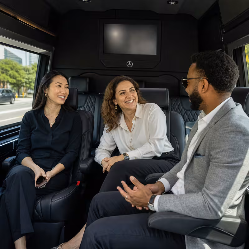 Group boarding a white charter bus for Corporate Transportation transportation in New Orleans
