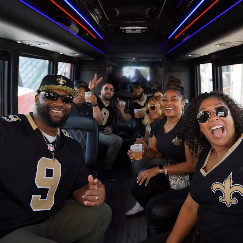 Group boarding a white charter bus for Sporting Event Transportation transportation in New Orleans